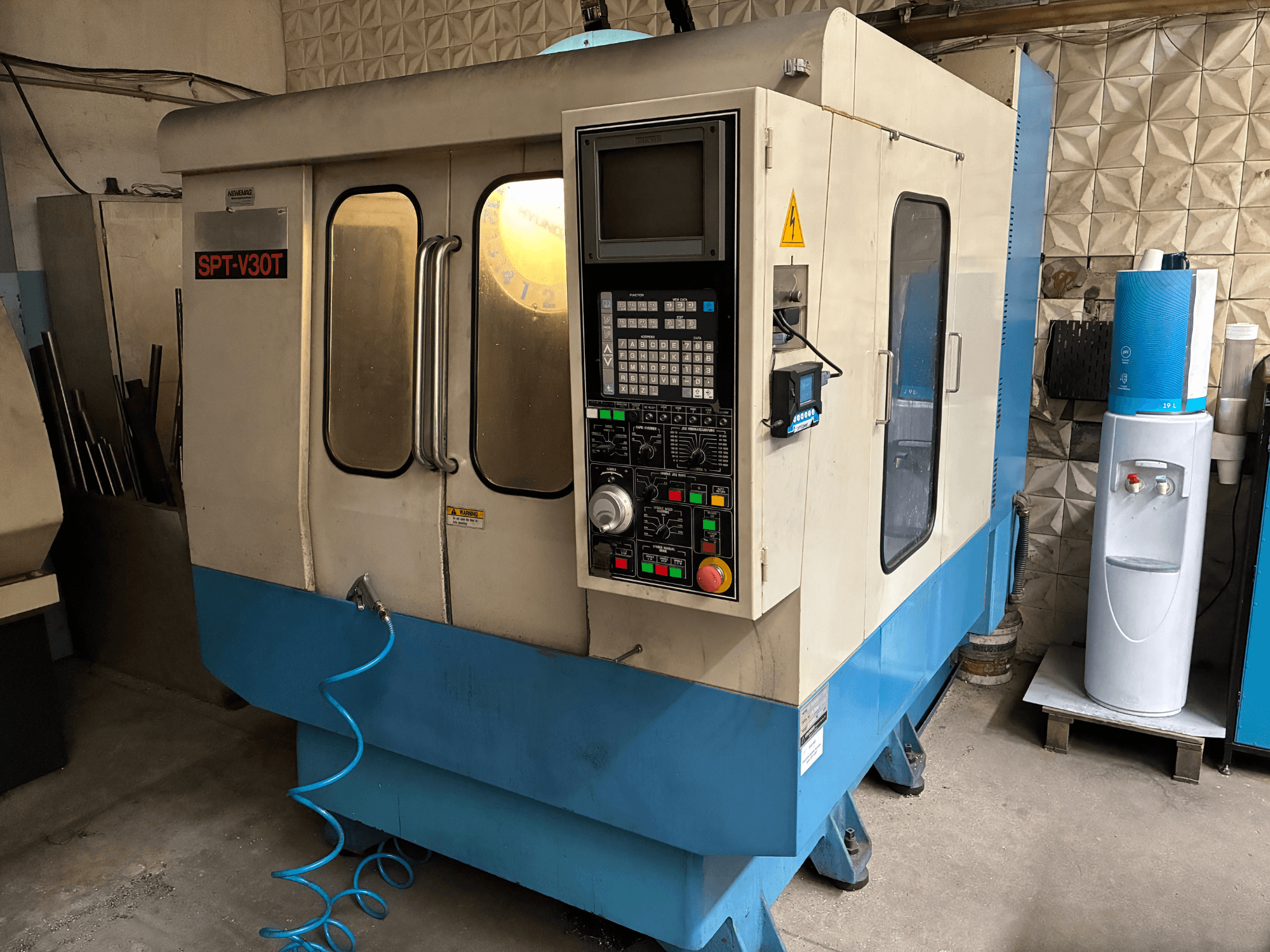 Máquina de moldagem por injeção hidráulica DEMAG Ergotech 150-610 Viva numa oficina, vista frontal com o painel de controlo visível.