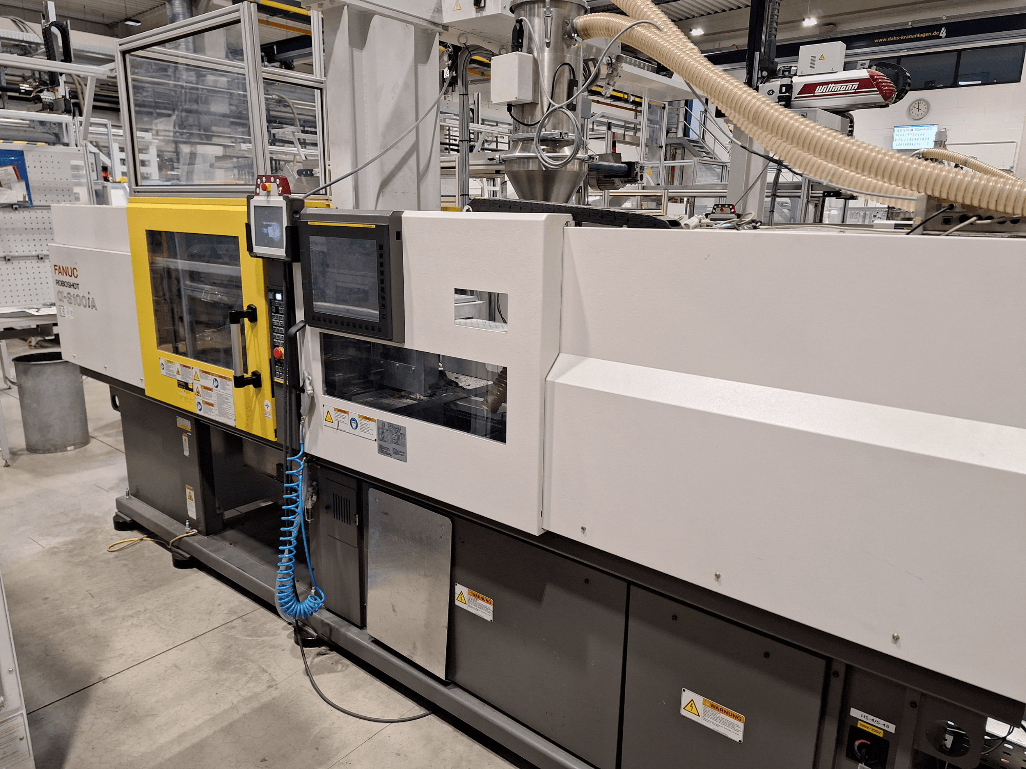 Máquina de moldagem por injeção FANUC Roboshot α-S300iA, vista frontal, com painel de controlo e componentes industriais visíveis.