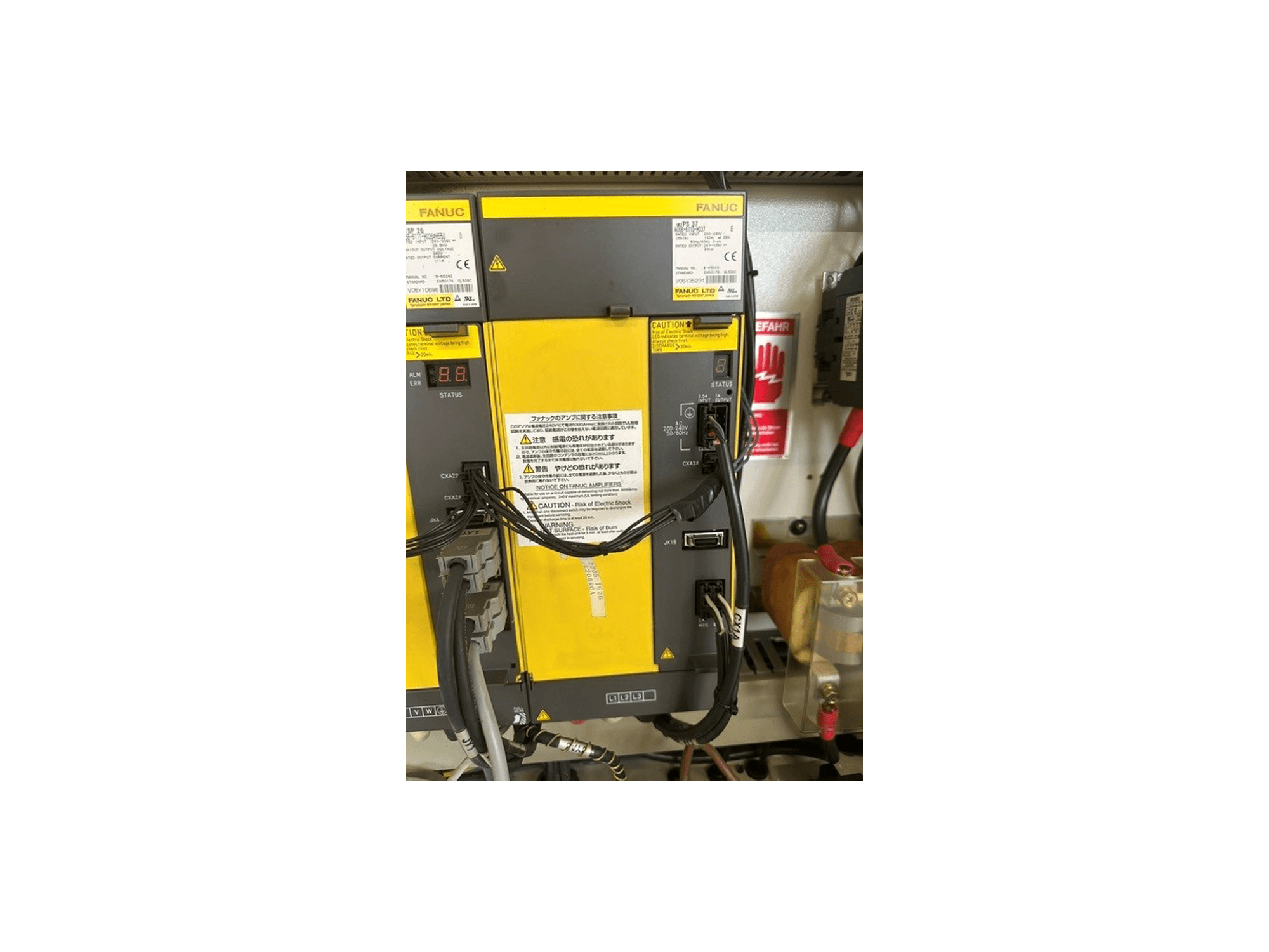 Painel de controlo do Centro de Maquinação Universal MIKRON HSM 600 U, mostrando os componentes FANUC, o visor de estado e as ligações elétricas.